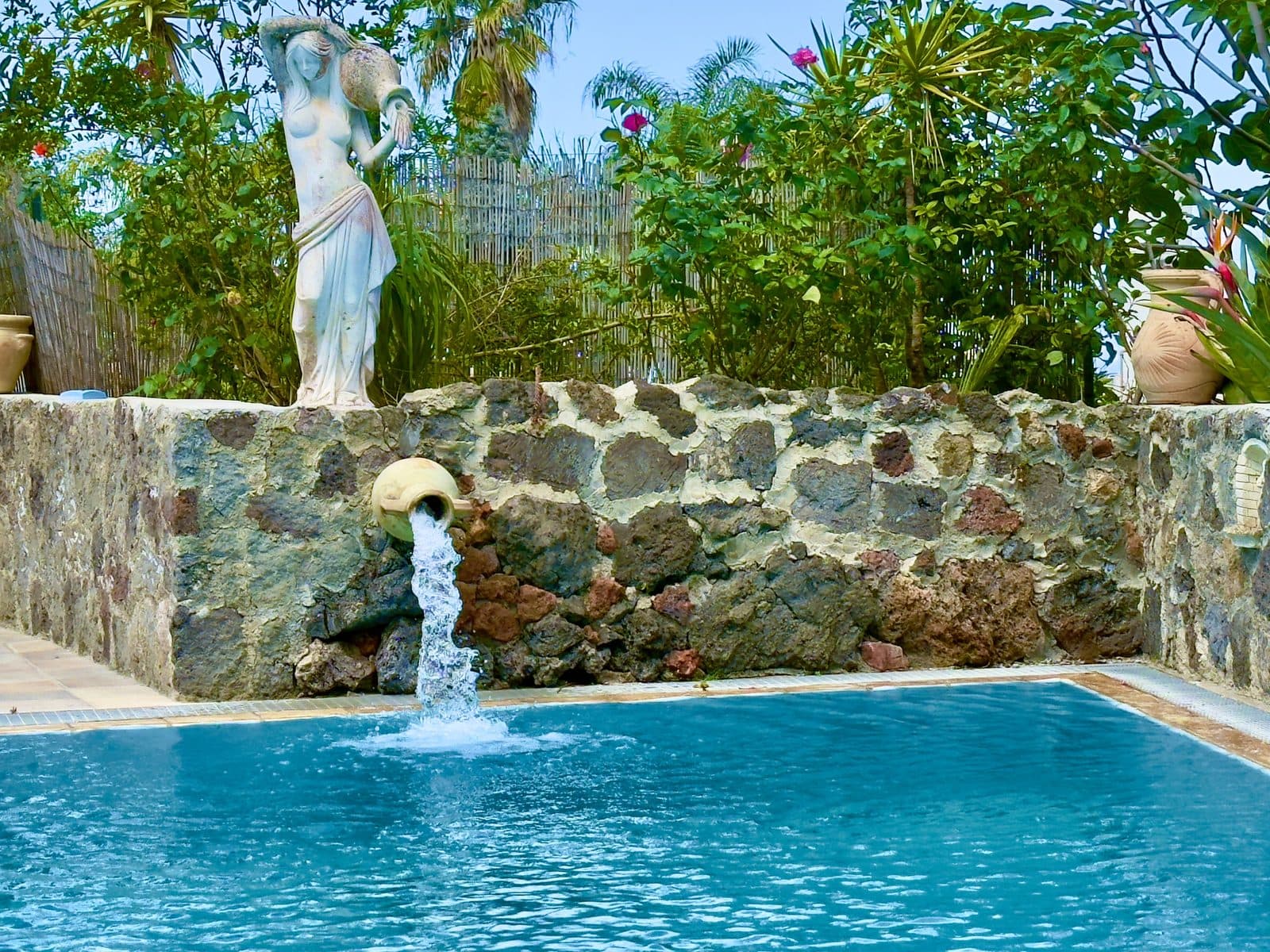 Piscina con fontana e statua classica