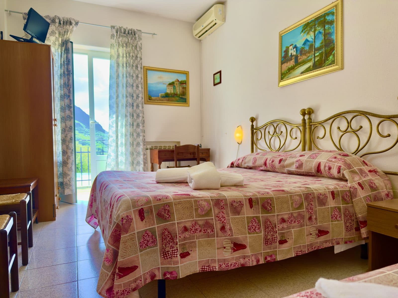 Camera Tripla con letto in ferro battuto e vista montagna